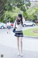 A woman in a school uniform is walking down the street.