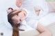 A young girl laying on a bed wearing a white dress.