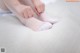 A woman is putting on a pair of white socks.