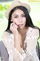 A woman wearing a straw hat sitting on a chair.