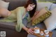 A woman laying on a couch with a tray of tea cups.