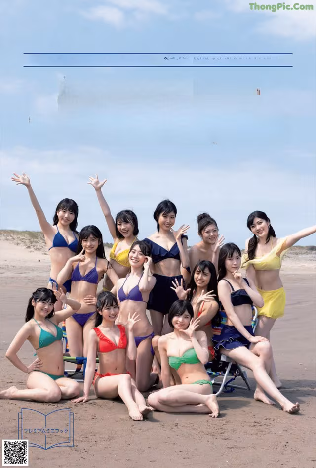 A group of women in bikinis posing for a picture on the beach.