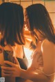 A couple of women standing next to each other in a bathroom.