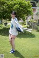 A woman standing on top of a lush green field.