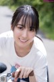 A young woman riding a bike on a road.