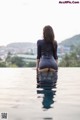 A woman in a black dress sitting in a pool.