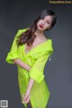 A woman in a bright green raincoat posing for a picture.