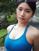 A woman in a blue tank top posing for a picture.