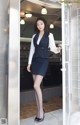 A woman in a business suit standing in a doorway.