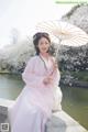 A woman in a pink dress holding an umbrella.