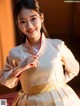 A young girl wearing a white and gold hanbok.