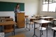 A woman standing at a podium in a classroom.