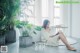 A woman sitting on the floor reading a book.