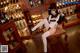 A woman sitting on a chair in front of a bar.