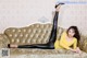 A woman laying on a couch wearing black leggings and high heels.