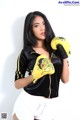 A woman in a black jacket and yellow boxing gloves.