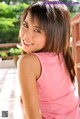 A woman in a pink tank top posing for a picture.