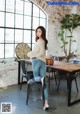 A woman sitting on a chair in front of a table.