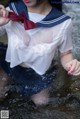 A woman in a sailor outfit is standing in the water.