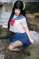 A woman in a sailor outfit sitting in the water.