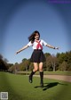 A woman in a school uniform is jumping in the air.