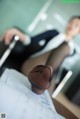 A woman in black stockings sitting at a desk with her feet up.