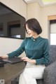 A woman sitting at a table with a laptop computer.