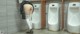 A woman standing in front of a row of urinals in a public restroom.