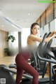 a woman in a white top and red leggings on a tread machine